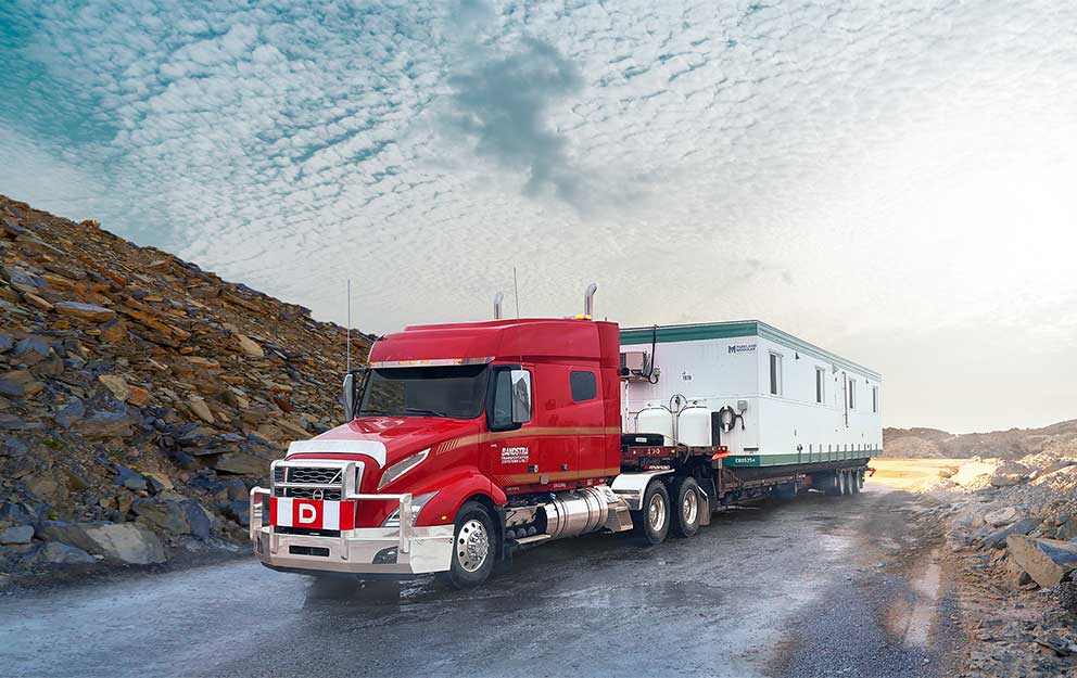 Bandstra heavy haul truck carrying portable housing unit  