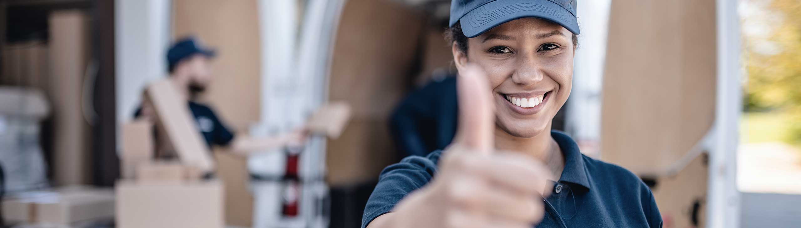 Bandstra team member giving thumbs up in front of company van being loaded with charity packages