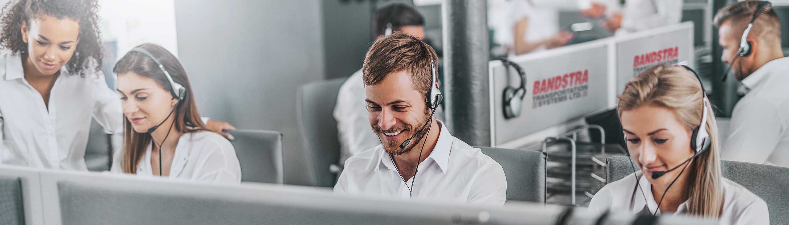 Bandstra employees in office wearing phone headsets