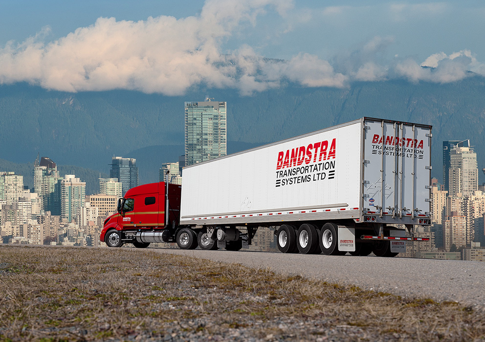 Bandstra tractor trailer driving toward British Columbia cityscape